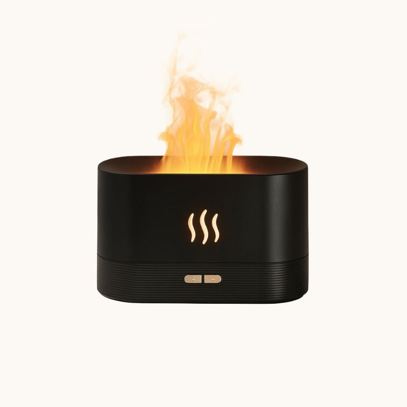 Black essential oil diffuser with yellow LED flame effect glowing softly against a light background.